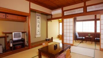 Une pièce de style japonais traditionnel, avec un sol recouvert de tatamis, une table basse et des portes coulissantes.