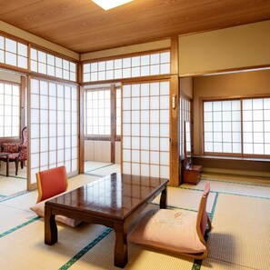 A traditional Japanese room with tatami flooring, a low wooden table, and sliding doors. - Hot Springs Inn 'unzen Iwaki Ryokan' (Unzen)