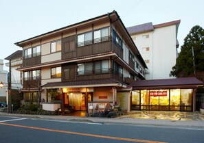 A multi-story building with a restaurant on the ground floor, featuring a traditional facade with wooden elements and a red awning. - Hot Springs Inn 'unzen Iwaki Ryokan' (Unzen)