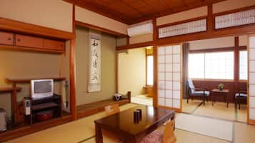 Una stanza tradizionale giapponese con pavimento in tatami, un tavolino e porte scorrevoli.
