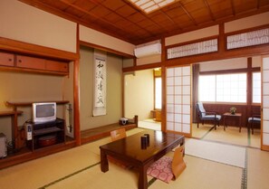 A traditional Japanese room with tatami flooring, a low table, and sliding doors. - Hot Springs Inn 'unzen Iwaki Ryokan' (Unzen)