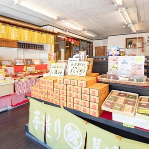 A store interior with shelves stocked with packaged goods, price tags, and a counter area. - Hot Springs Inn 'unzen Iwaki Ryokan' (Unzen)
