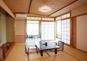A traditional Japanese room with tatami flooring, a low table, and sliding doors. - Hot Springs Inn 'unzen Iwaki Ryokan' (Unzen)