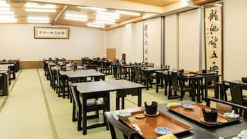 Una habitación japonesa tradicional con esteras de tatami, mesas y sillas de madera.