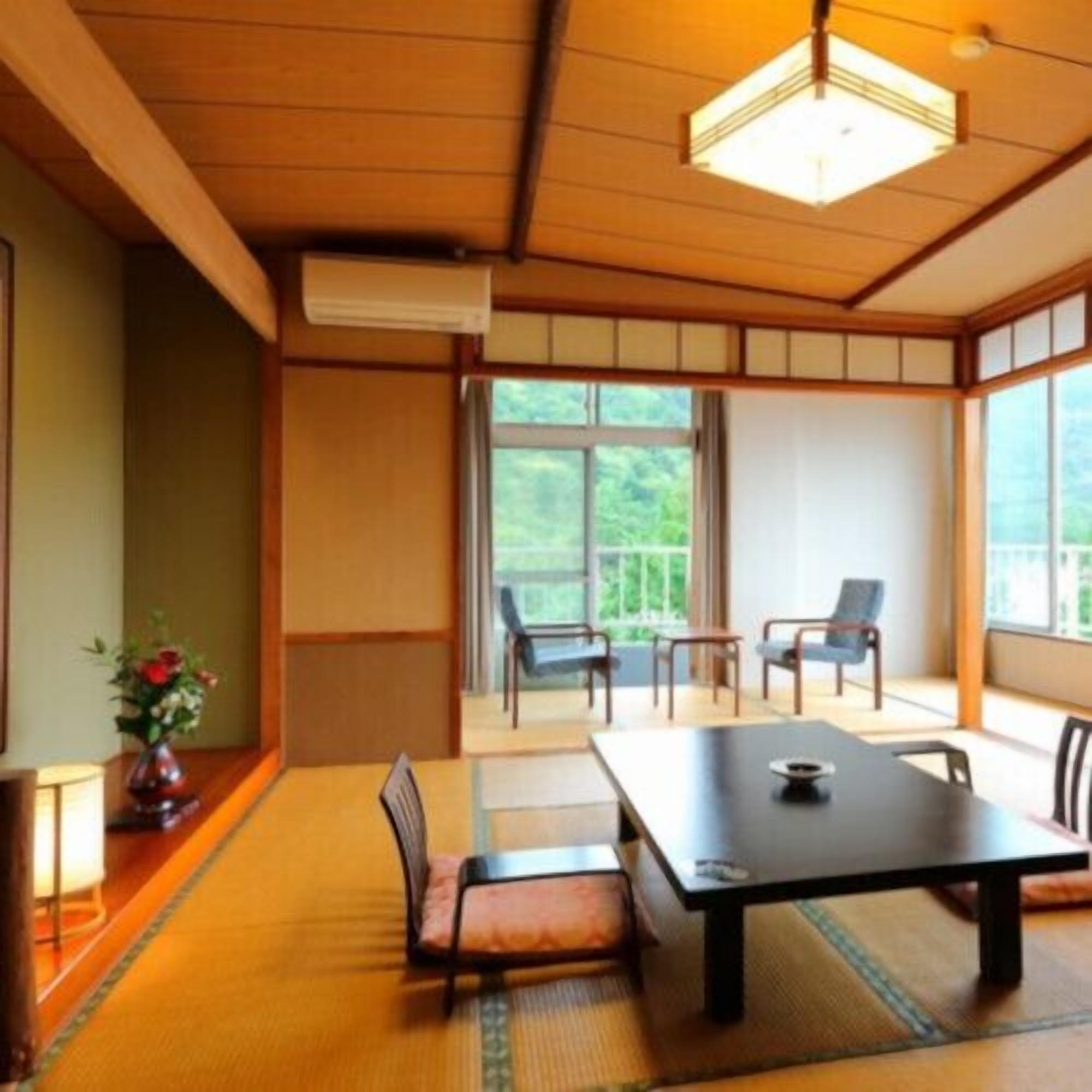 Ein traditioneller japanischer Raum mit Tatami-Boden, niedrigem Tisch und Schiebetüren.