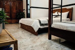 A room with two beds, a wooden wardrobe, a small table, and a potted plant. - CT Morning Hotel (Can Tho)