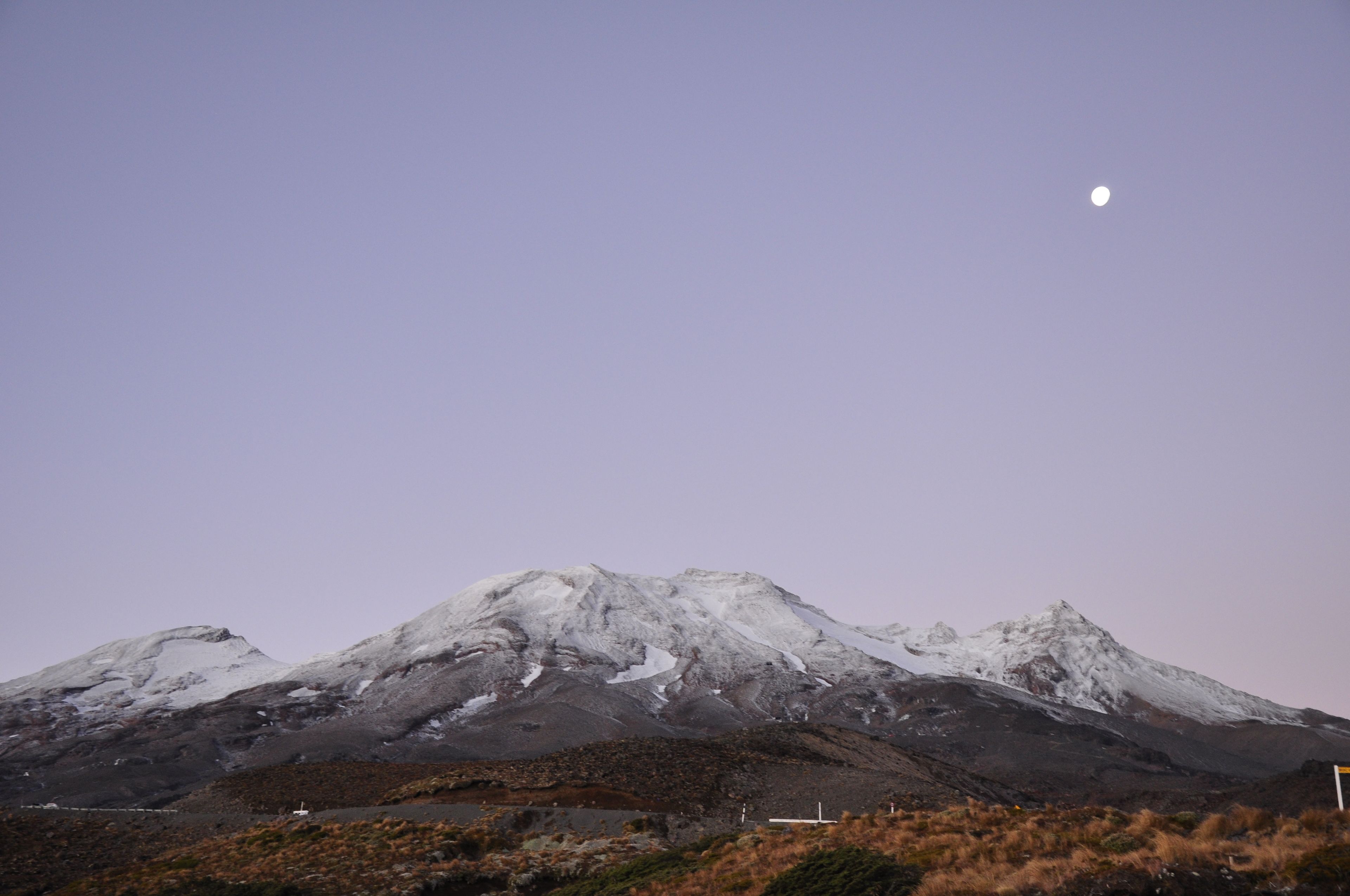 Una montaña con picos nevados bajo un cielo despejado.