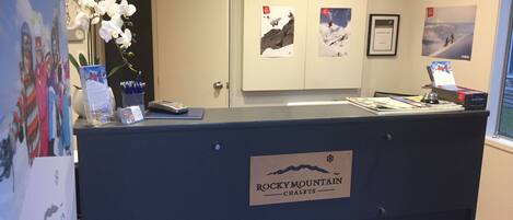 Um balcão de recepção com uma placa que diz 'ROCKY MOUNTAIN CHALETS'.