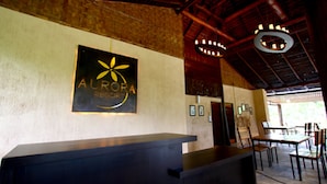 A reception area with a reception desk, a sign reading "AURORA RESORT", and a dining area with tables and chairs. - Aurora Resort Chiang Dao (Chiang Dao)