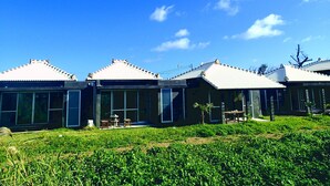 A row of modern houses with flat roofs, large windows, and a well-maintained lawn. - Fu-rai-so Private Villa (Nakijin)