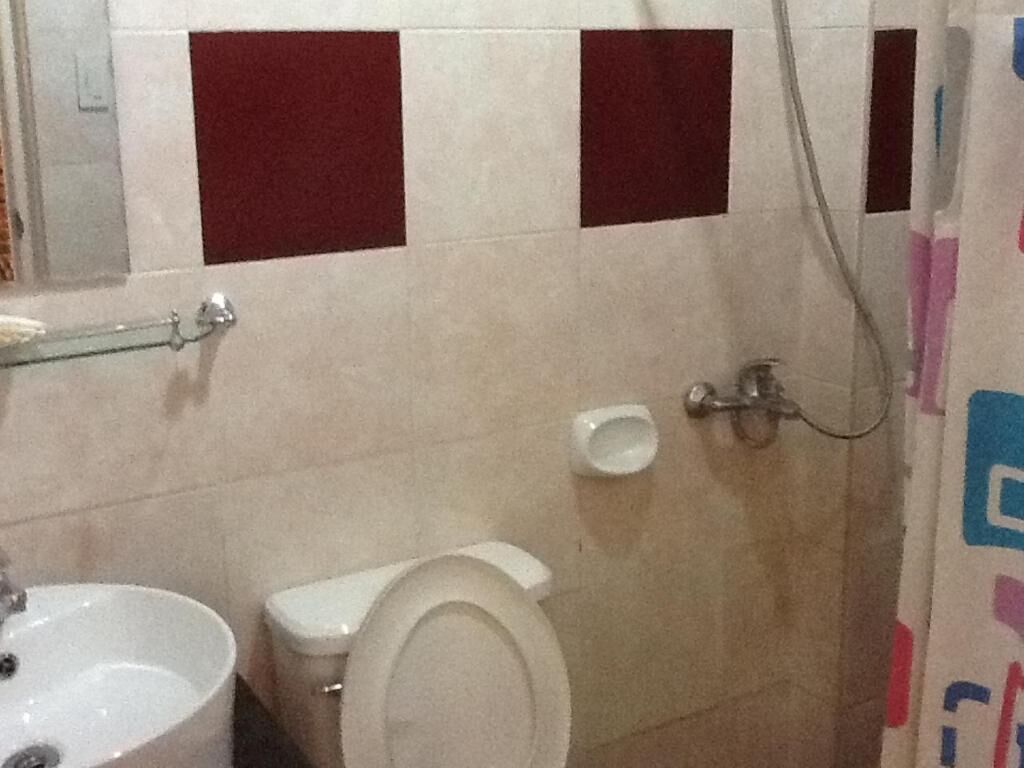 A bathroom with a toilet, sink, and shower.