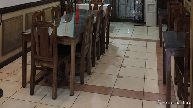 A dining area with a long table, wooden chairs, a chandelier, and a coffee shop sign. - Darunday Manor (Tagbilaran)