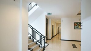A hotel interior with a staircase, a hallway, and an exit sign. - Hotel 88 Mangga Besar 120 (Jakarta)