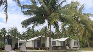 A beachfront property with two single-story cabins, each with a balcony and a small porch area.