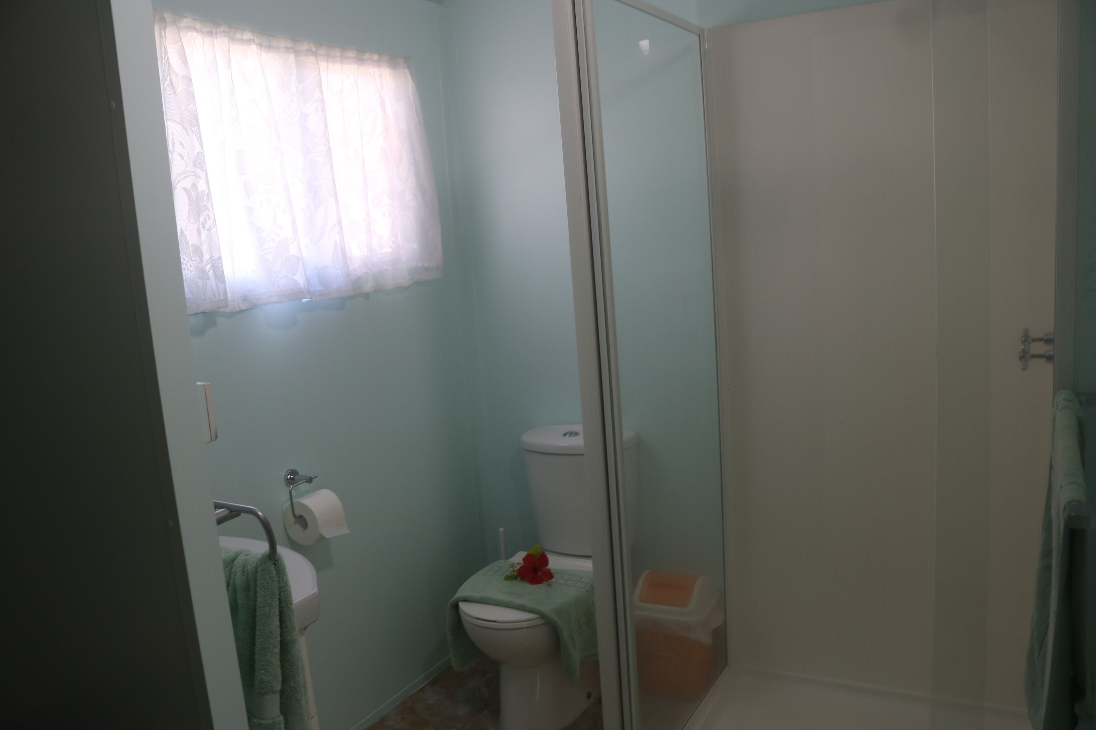 A bathroom with a toilet, sink, and shower area.