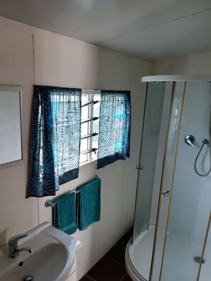 Eenpersoonskamer, aan tuin | Badkamer met wastafel