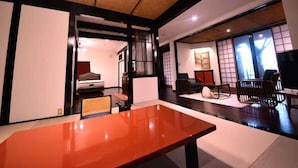 Une pièce de style japonais traditionnel, avec un sol recouvert de tatamis, une table basse et des portes coulissantes.