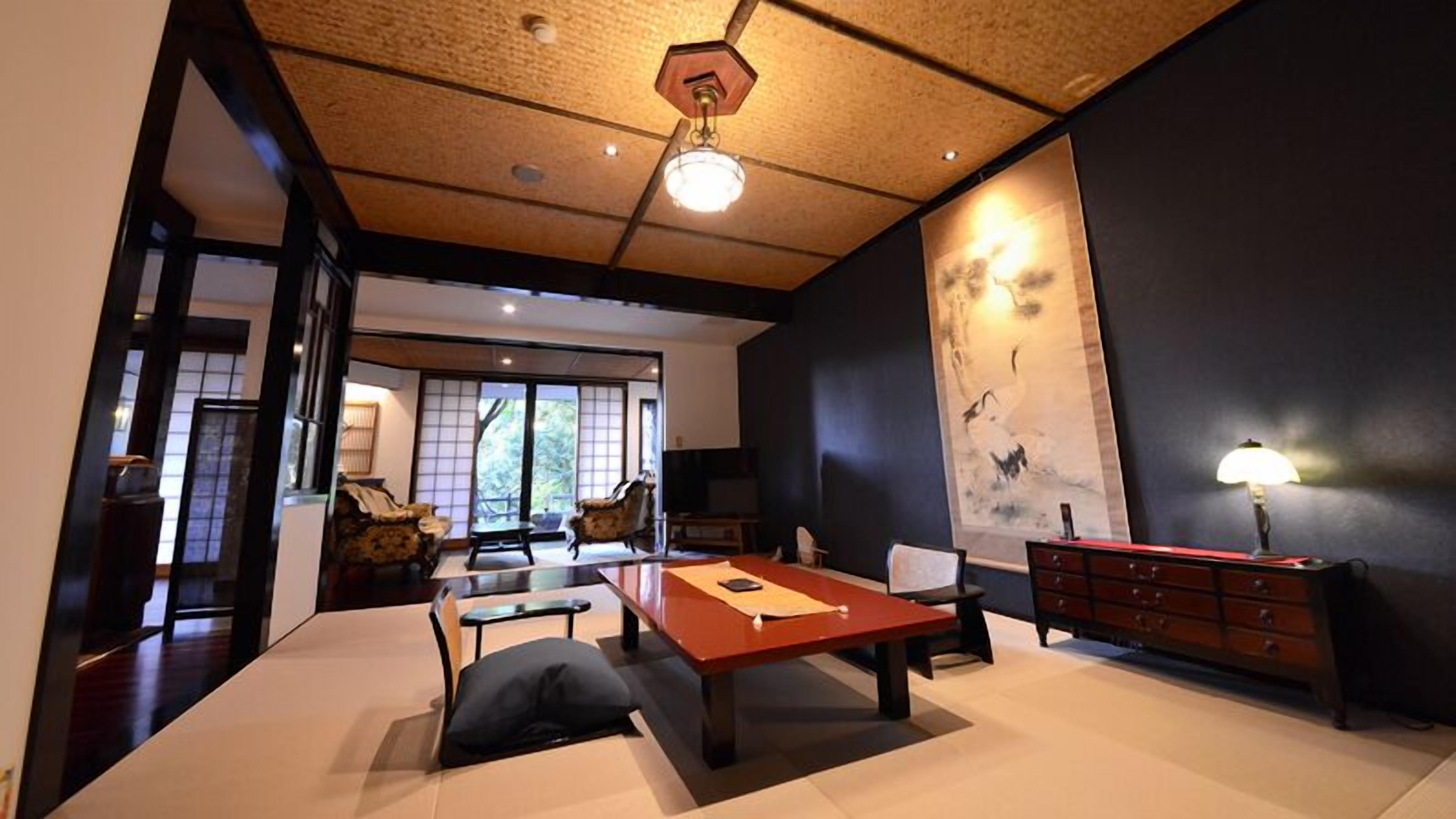 A traditional Japanese-style room with tatami flooring, a low table, and a sliding door leading to a balcony.