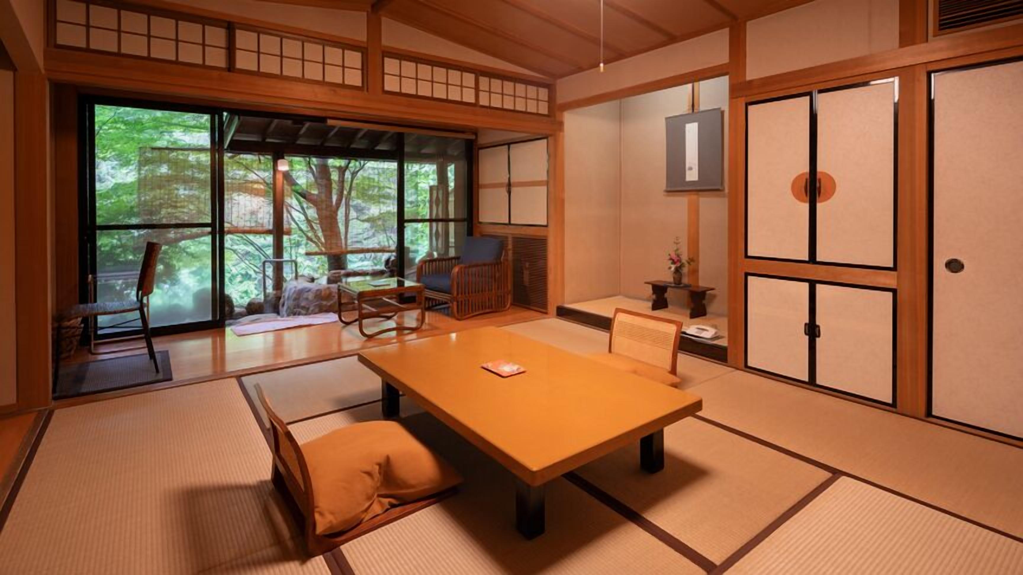 Ein traditioneller japanischer Raum mit Tatami-Bodenbelag, einem niedrigen Tisch und gleitenden Türen.