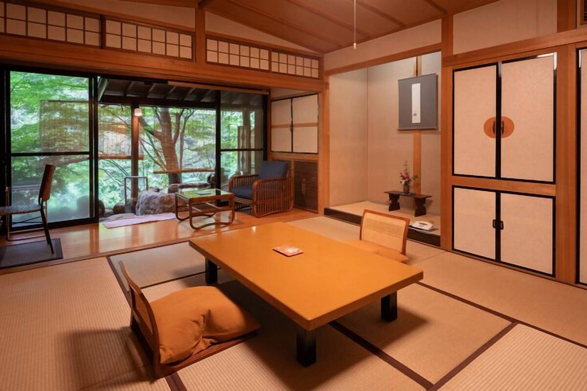 A traditional Japanese room with tatami flooring, a low table, and sliding doors.