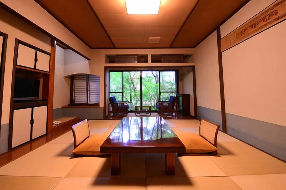 A traditional Japanese-style room with tatami flooring, a low table, and sliding doors.