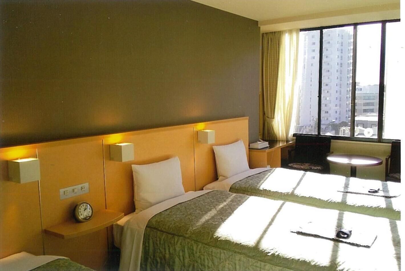 Ein Hotelzimmer mit einem großen Bett, Nachttischen, einem Schreibtisch und einem Sessel.