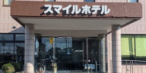 A hotel entrance with a sign reading "Smile Hotel" and a bicycle parked outside. - Smile Hotel FukuokaOkawa (Okawa)