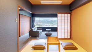 Ett traditionellt japanskt rum med tatamimattor på golvet, ett lågt träbord, kuddar och en skjutbar shojiskärm.