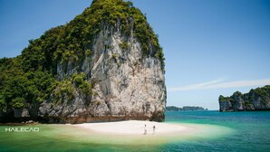 A large limestone island with a white sandy beach and clear turquoise waters. - Hung Long Harbour Hotel (Hai Phong)