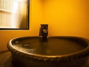 A large, round hot tub with a faucet in a room with yellow tiled walls. - Shirosaki Onsen Umashi Kakureya Yuyado Yamayoshi (Toyooka)