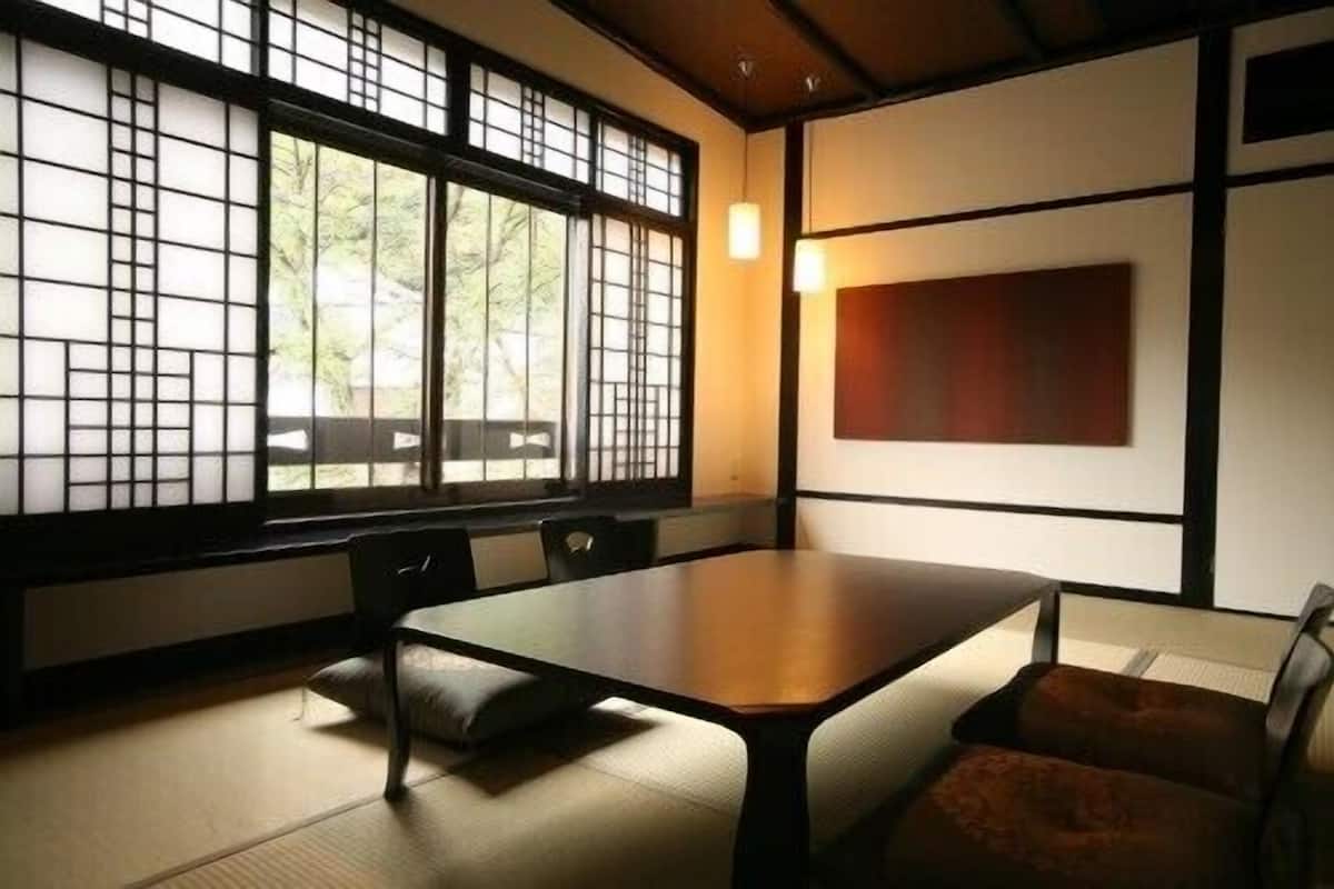 Perinteinen japanilainen huone, jossa on tatamimatto, matala pöytä ja liukuvat ovet.