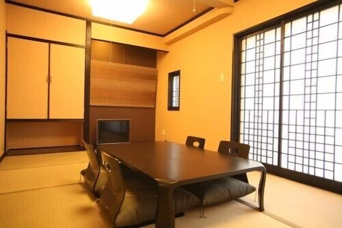 Perinteinen japanilainen huone, jossa on tatamimatto, matala pöytä ja liukuvat ovet.