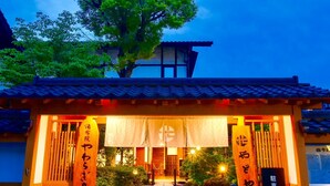 Een traditioneel Japans gebouw met een pannendak, een houten entreepoort en een bord met Japanse karakters.