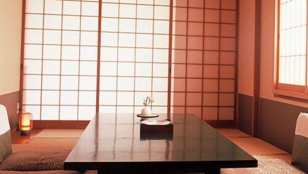 A traditional Japanese room with tatami flooring, a low table, and shoji screens. - Ryokan Igaya (Amakusa)