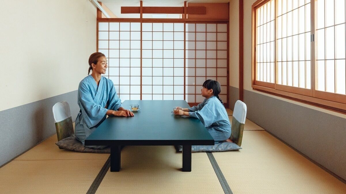 Een traditionele Japanse kamer met tatami vloerbedekking, een lage tafel en shoji schermen.
