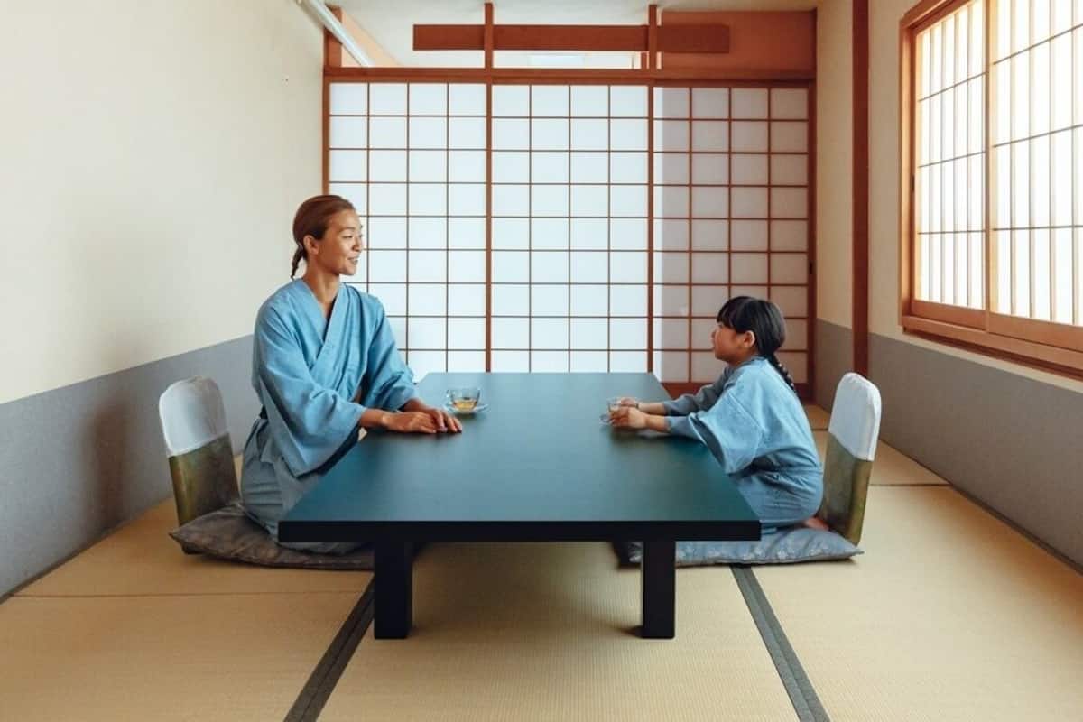 Ein traditioneller japanischer Raum mit Tatami-Böden, einem niedrigen Tisch und Shoji-Schiebetüren.