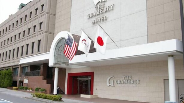 The Gramercy Hotel with a prominent sign and two flags, one American and one Japanese. - The Gramercy (Shunan)
