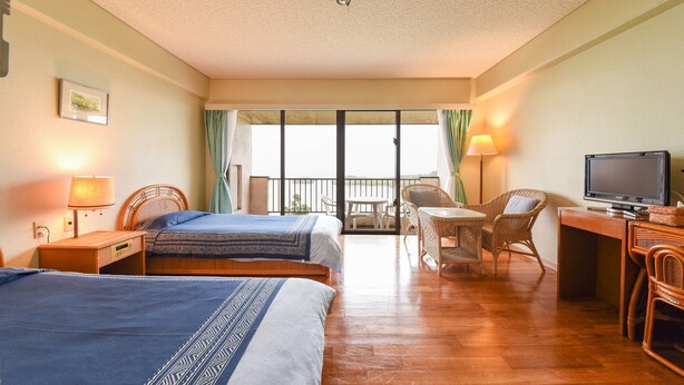 A hotel room with two beds, a desk with a television, a chair, and a balcony with a view. - Pension Hoshi NO Suna (Taketomi)