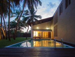 Una piscina al aire libre, sillones reclinables de piscina