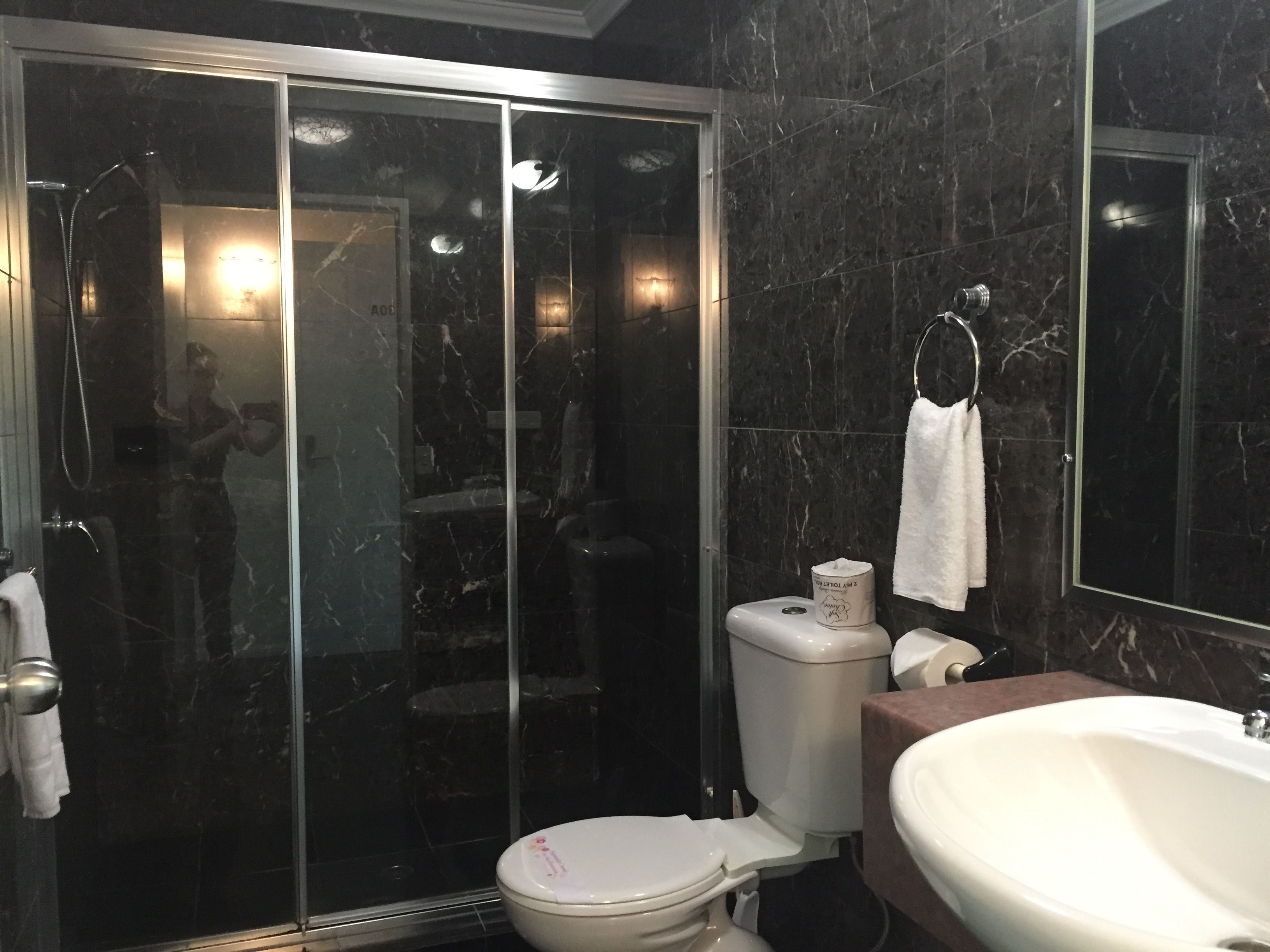 Une salle de bain moderne avec une douche à parois de verre, des toilettes et un lavabo.