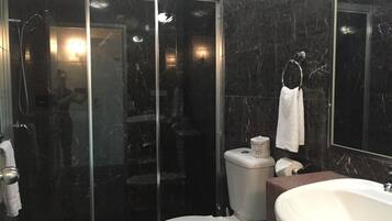 Une salle de bain moderne avec une douche à parois de verre, des toilettes et un lavabo.