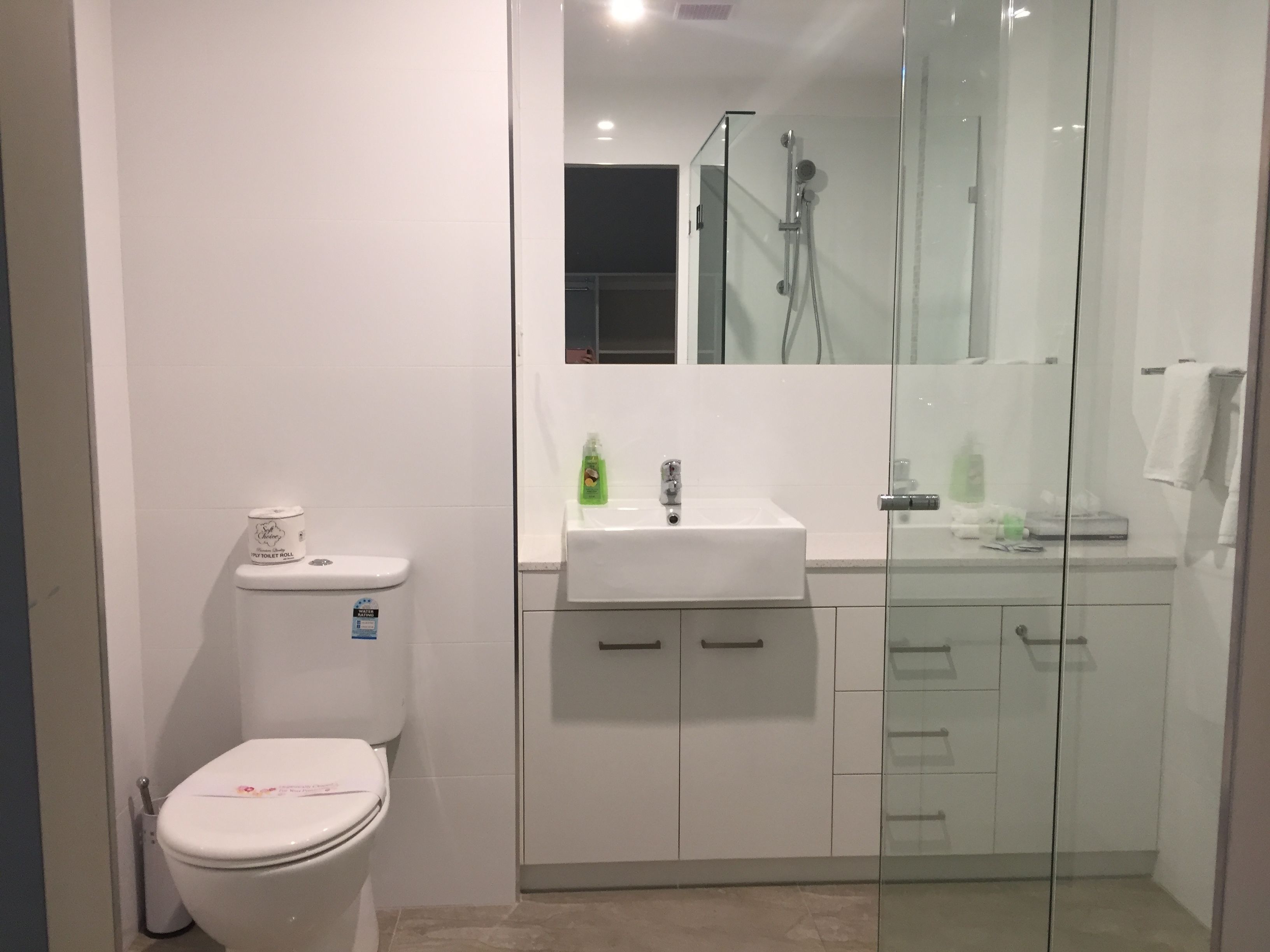 A modern bathroom with a toilet, a sink, and a glass-enclosed shower.