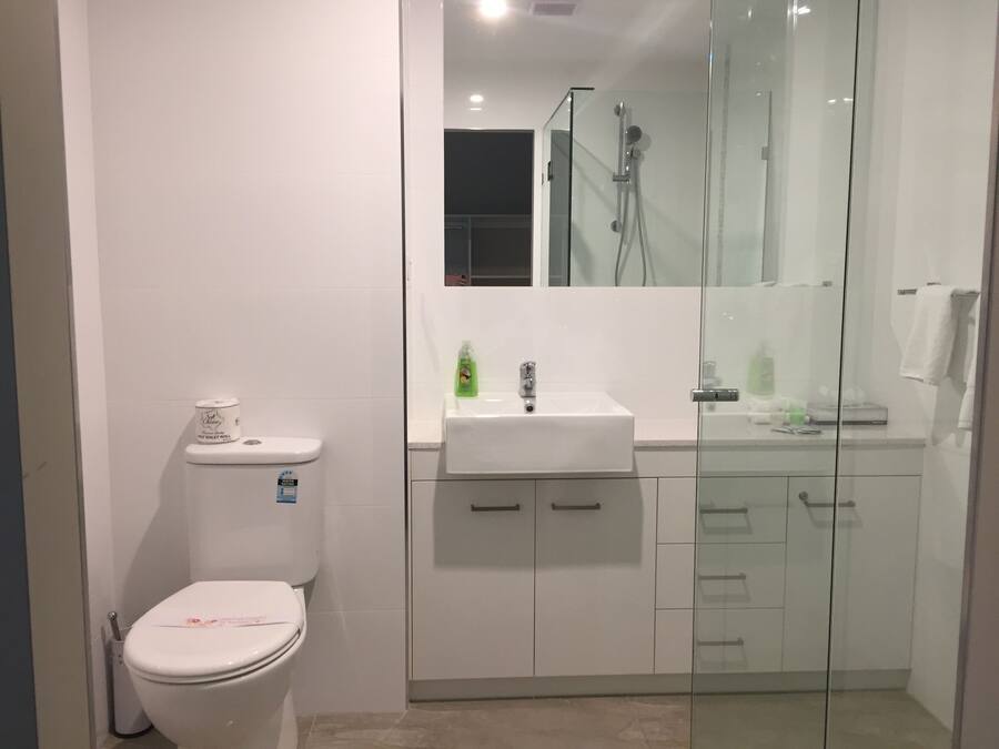 A modern bathroom with a toilet, a sink, and a glass-enclosed shower.