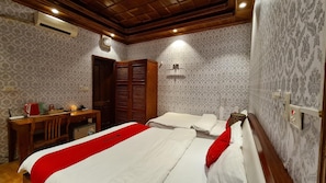 A hotel room with two beds, a desk, a wardrobe, and a mirror. - Green Hotel (Hanoi)
