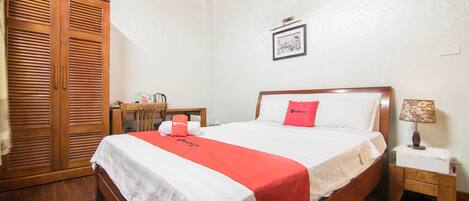 A neatly arranged bedroom with a bed, bedside table, lamp, and wardrobe.