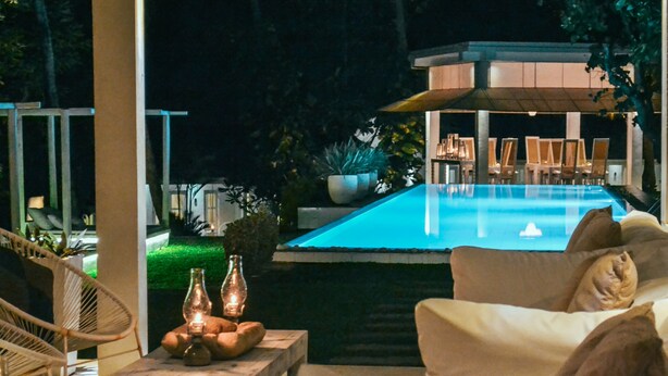An outdoor pool area with lounge chairs and a table with candles. - W15 Escape (Ahangama)