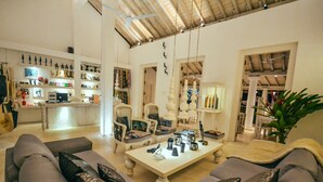 A spacious living area with a high ceiling, a central coffee table, and a seating arrangement including a sofa and chairs. - W15 Escape (Ahangama)
