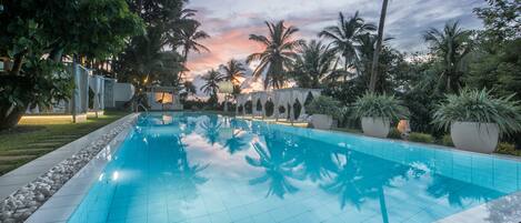 Una piscina al aire libre, camas de piscina gratis, sombrillas