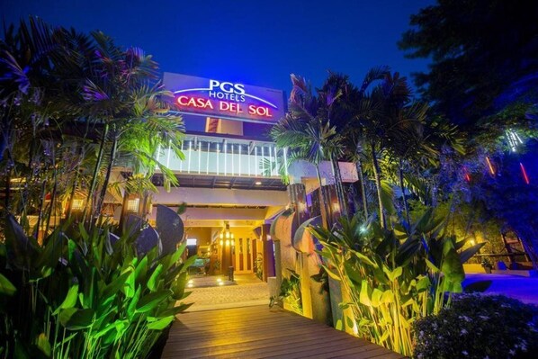 The exterior of PGS Hotels Casa Del Sol with a well-lit entrance and tropical plants. - Pgs Hotels Casa Del Sol (Kata)