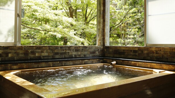 A hot tub with a view of a lush garden through a window. - Hashinoya Annex Ransui (Kobe)